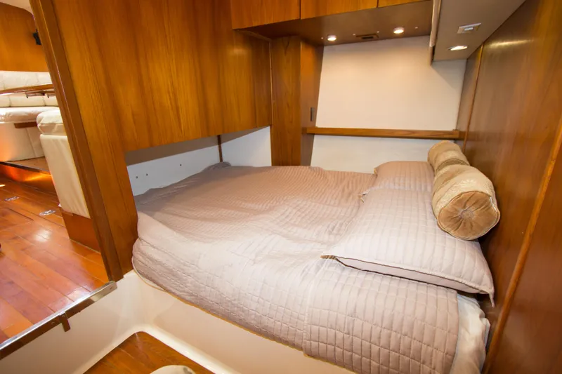 Sparrow Yacht Photos Pics 1995 Tiara Yachts 4000 Express cabin with cozy bed and wooden interior.