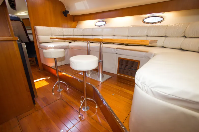 Sparrow Yacht Photos Pics 1995 Tiara Yachts 4000 Express interior with white leather seating and wooden flooring.