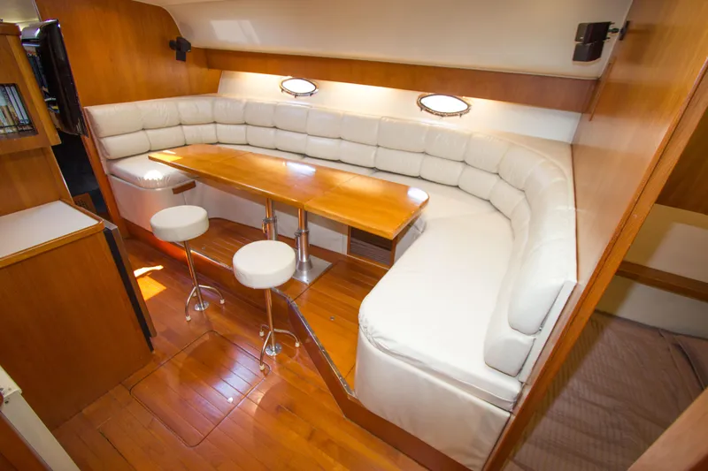 Sparrow Yacht Photos Pics 1995 Tiara Yachts 4000 Express interior with white leather seating and wooden table.
