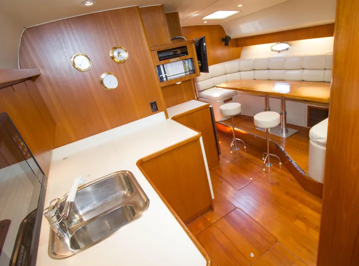 Sparrow Yacht Photos Pics 1995 Tiara Yachts 4000 Express interior with wood finish, kitchenette, and seating area.
