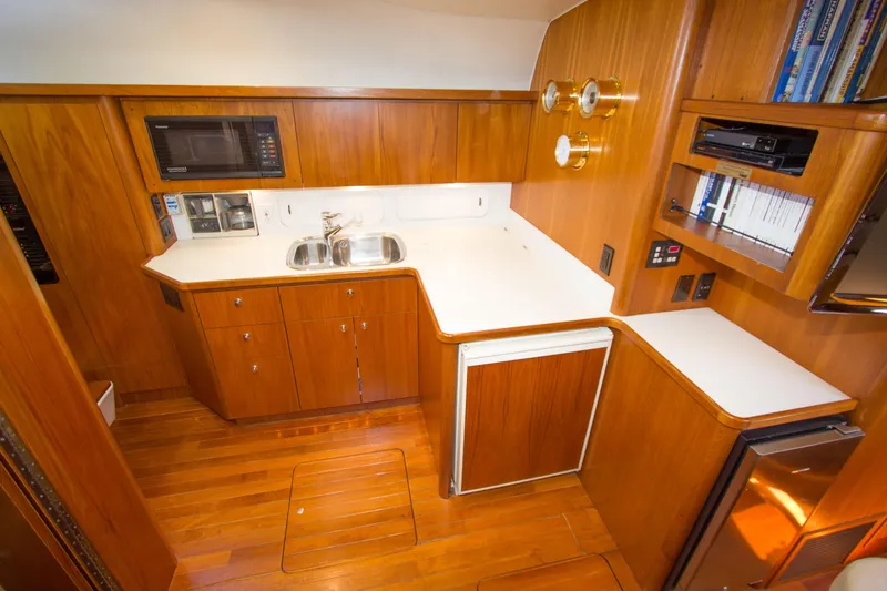 Sparrow Yacht Photos Pics 1995 Tiara Yachts 4000 Express galley with wood cabinetry, sink, microwave, and compact fridge.