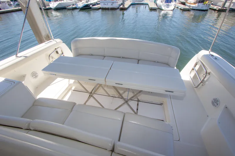 Sparrow Yacht Photos Pics 1995 Tiara Yachts 4000 Express interior with white seating and table, docked at marina.