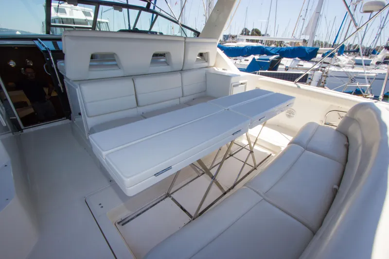 Sparrow Yacht Photos Pics 1995 Tiara Yachts 4000 Express interior with white seating and table, docked at marina.