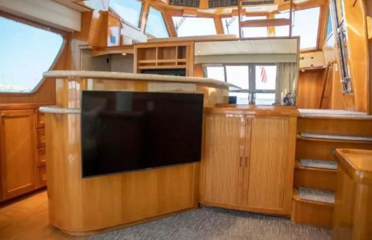 Prudence Yacht Photos Pics Interior of 2005 McKinna 57 Pilothouse yacht with wood cabinetry and large TV.