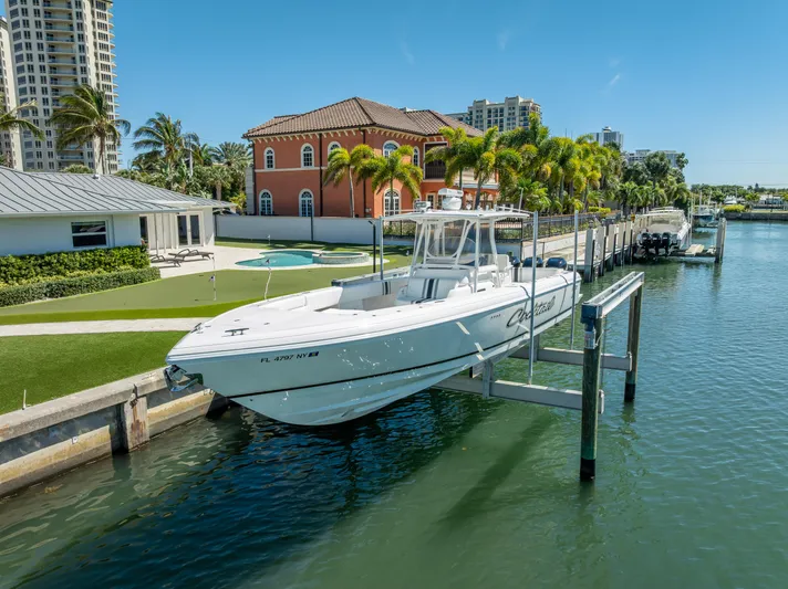  Yacht Photos Pics Intrepid 370 Open 2010 boat docked by waterfront homes, clear blue sky.