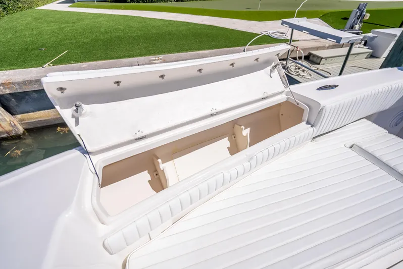  Yacht Photos Pics Open storage compartment on a 2010 Intrepid 370 Open boat, docked near green lawn.