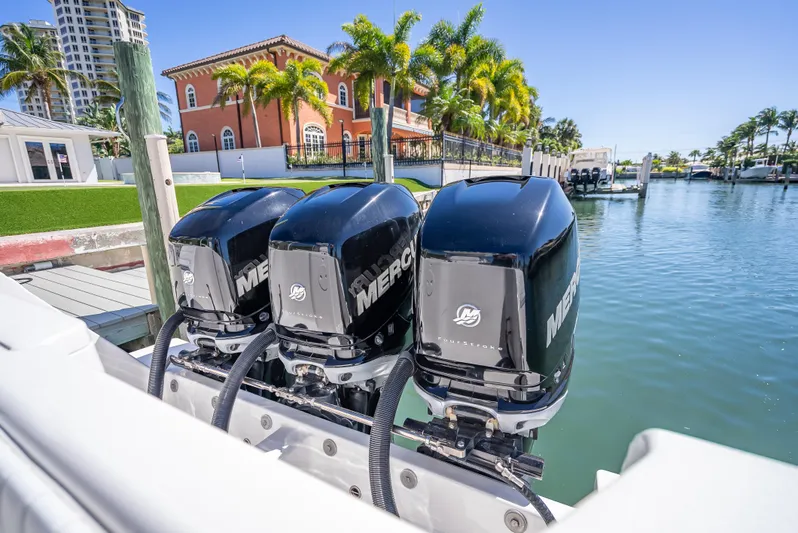  Yacht Photos Pics Triple Mercury outboard engines on a 2010 Intrepid 370 Open, docked by waterfront homes.