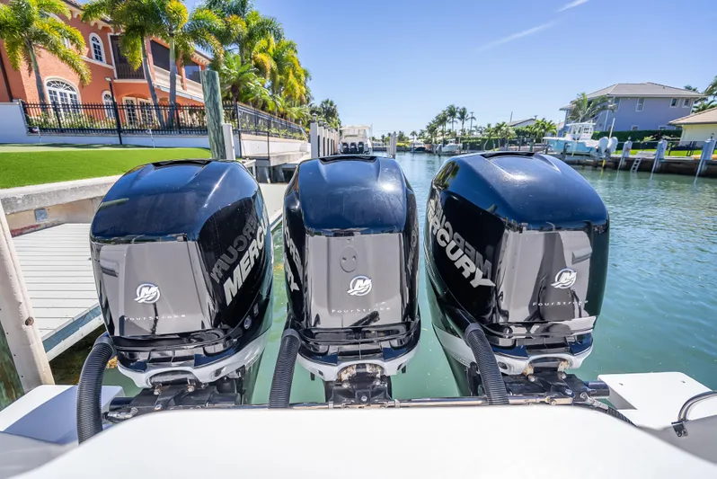  Yacht Photos Pics Triple Mercury outboard engines on a 2010 Intrepid 370 Open boat docked by a canal.