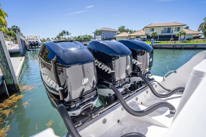  Yacht Photos Pics Triple Mercury outboard engines on a 2010 Intrepid 370 Open boat docked by waterfront homes.