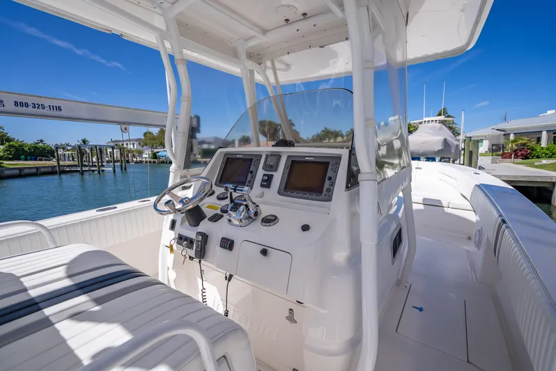  Yacht Photos Pics 2010 Intrepid 370 Open boat cockpit with dual screens and steering wheel, docked by the water.