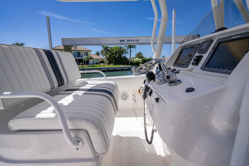  Yacht Photos Pics 2010 Intrepid 370 Open boat interior with helm and seating, featuring modern controls and striped upholstery.