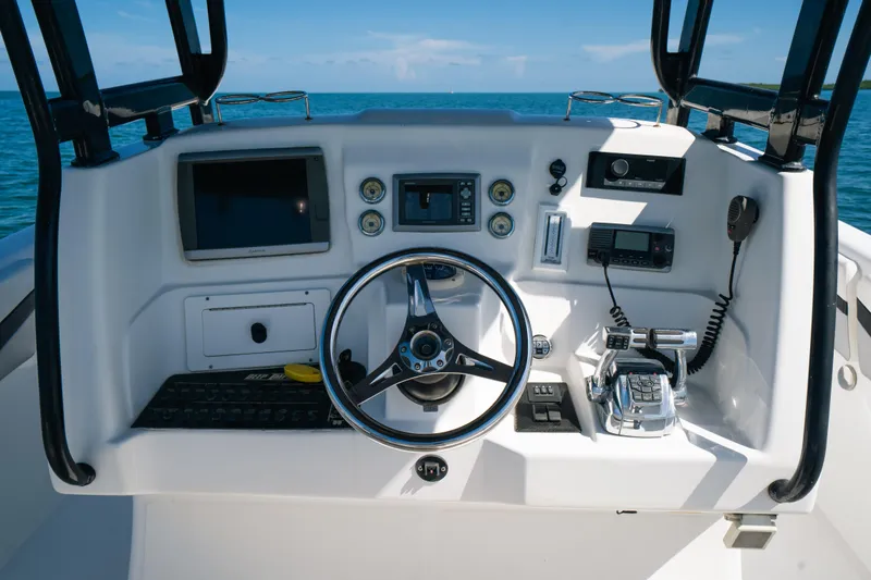  Yacht Photos Pics Control panel of a 2013 Deep Impact 33 boat with steering wheel and navigation equipment.