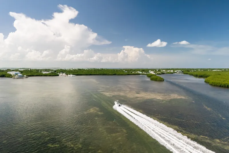  Yacht Photos Pics Aerial view of a 2013 Deep Impact 33 boat speeding through scenic coastal waters.