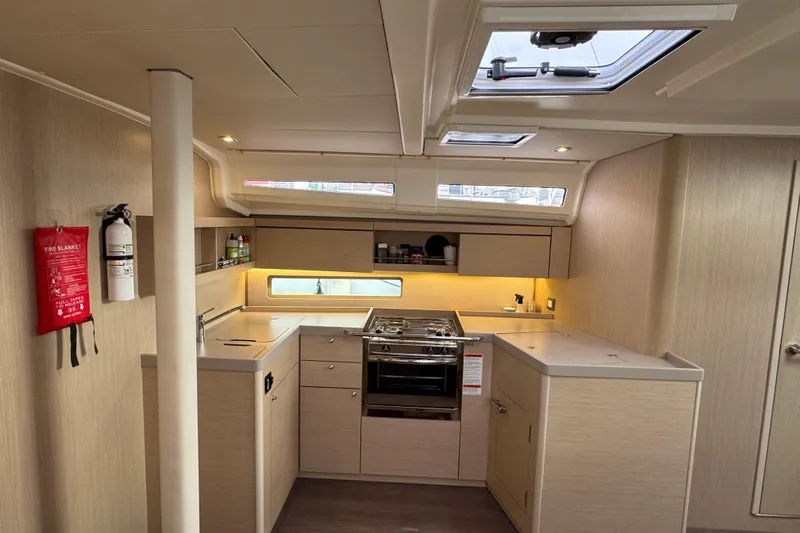 Madras Yacht Photos Pics Modern kitchen interior of 2022 Beneteau Oceanis 40.1 yacht, featuring sleek cabinetry and appliances.