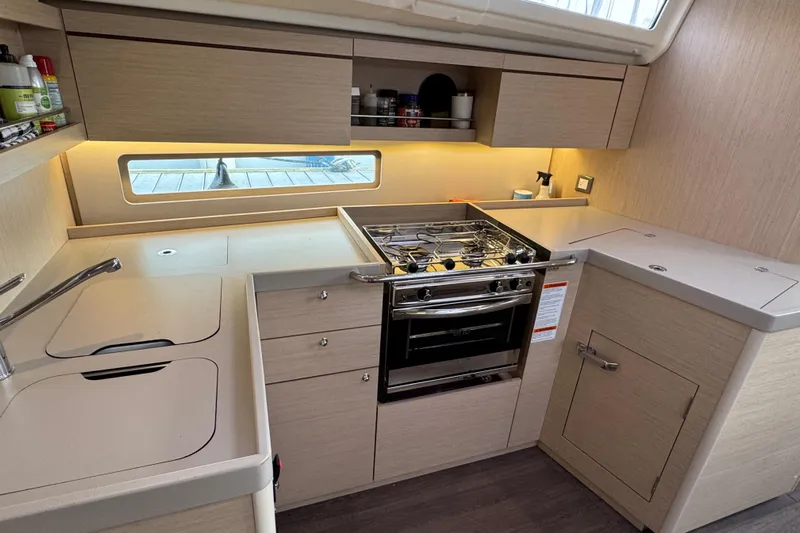 Madras Yacht Photos Pics Modern kitchen interior of 2022 Beneteau Oceanis 40.1 yacht with stove and cabinetry.
