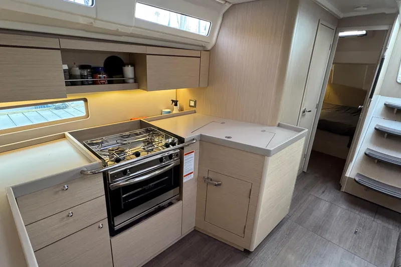 Madras Yacht Photos Pics Modern kitchen interior of 2022 Beneteau Oceanis 40.1 yacht with stove and cabinetry.