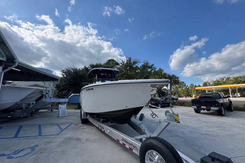  Yacht Photos Pics 2025 Fountain 32 NX boat on trailer under a partly cloudy sky.
