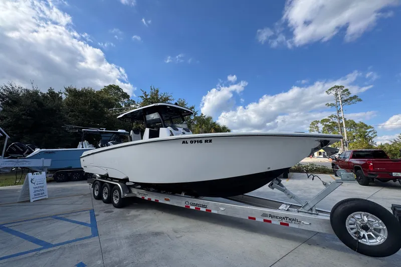  Yacht Photos Pics 2025 Fountain 32 NX boat on trailer under blue sky, parked outdoors.