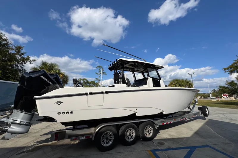  Yacht Photos Pics 2025 Fountain 32 NX boat on trailer under blue sky with clouds.