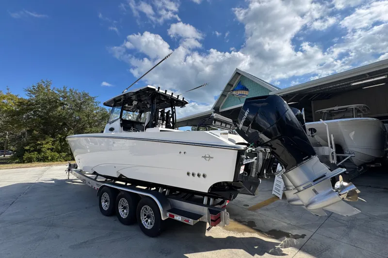  Yacht Photos Pics 2025 Fountain 32 NX boat on trailer, parked outdoors under a blue sky.