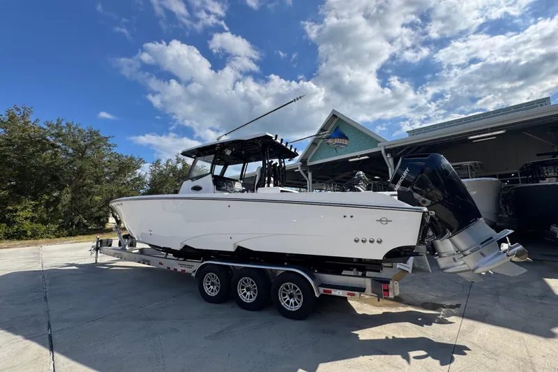  Yacht Photos Pics 2025 Fountain 32 NX boat on trailer under blue sky, parked outdoors.