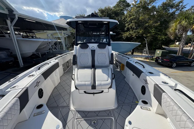  Yacht Photos Pics 2025 Fountain 32 NX boat with sleek seating and modern design in a marina setting.