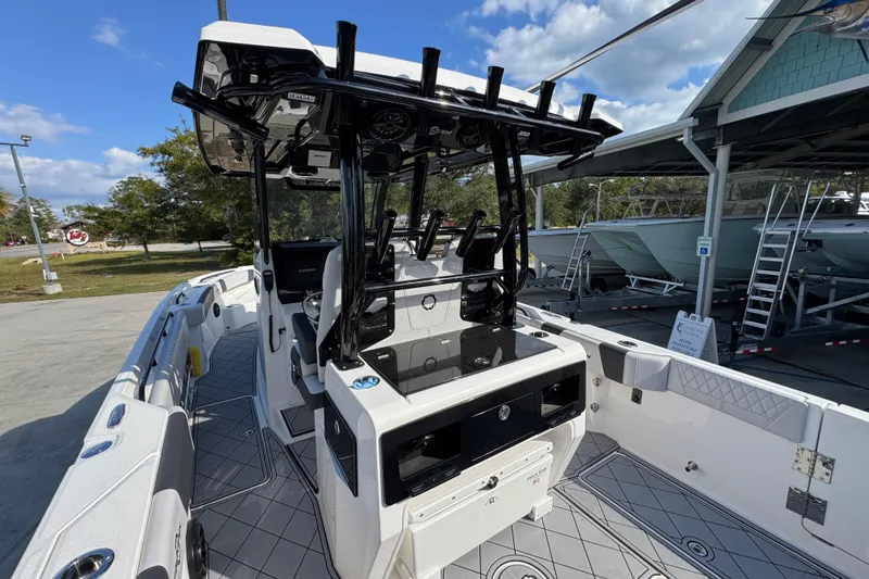  Yacht Photos Pics 2025 Fountain 32 NX boat interior with modern helm and seating, docked under clear skies.