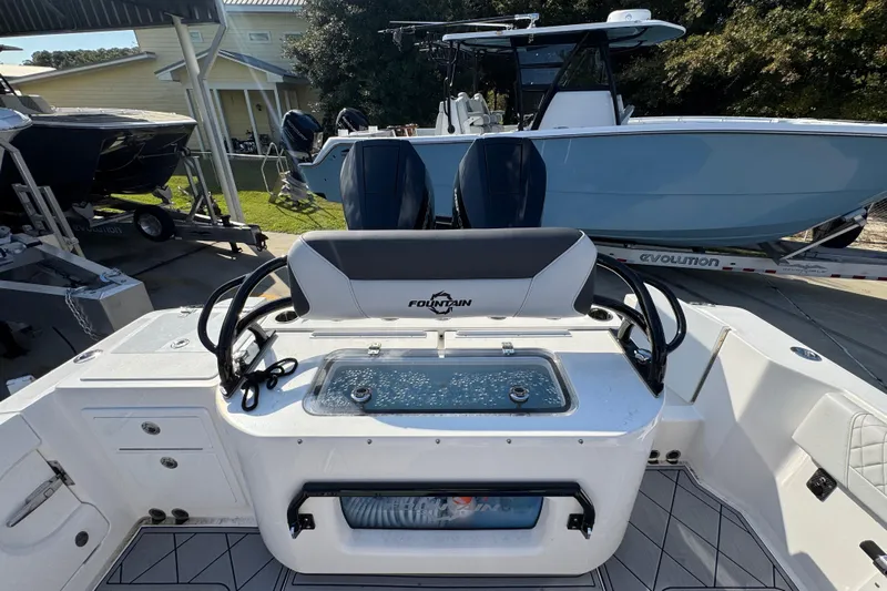  Yacht Photos Pics 2025 Fountain 32 NX boat interior with seating and control panel, parked outdoors.