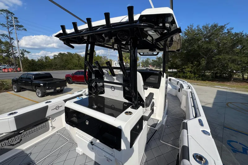  Yacht Photos Pics 2025 Fountain 32 NX boat interior with modern helm and seating, parked outdoors.