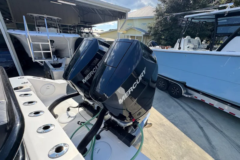  Yacht Photos Pics 2025 Fountain 32 NX boat with dual Mercury outboard engines in a marina setting.