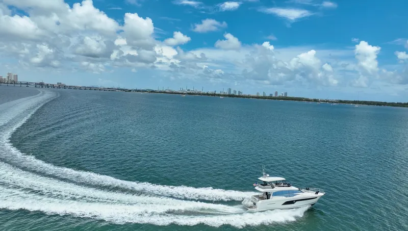 Soiral Yacht Photos Pics Luxury 2023 Prestige 520 yacht cruising on open water under a clear blue sky.
