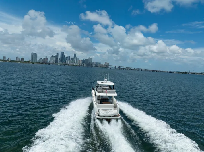 Soiral Yacht Photos Pics Prestige 520 yacht cruising near city skyline under blue sky, 2023 model.