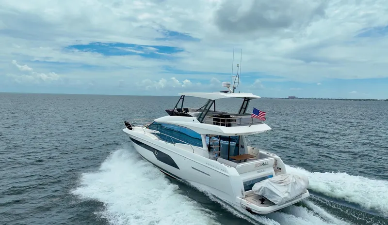 Soiral Yacht Photos Pics 2023 Prestige 520 yacht cruising on open sea under a partly cloudy sky.