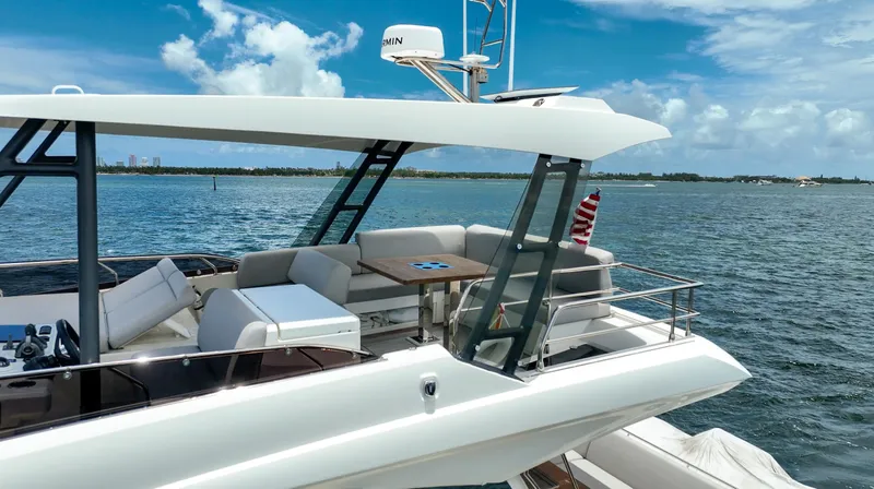 Soiral Yacht Photos Pics Luxury 2023 Prestige 520 yacht on serene blue waters under a clear sky.