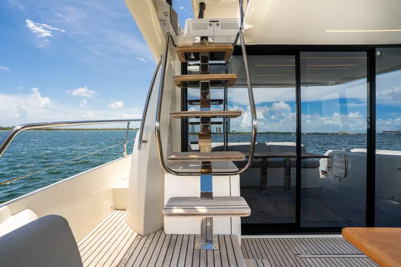 Soiral Yacht Photos Pics Luxury yacht deck with modern staircase, Prestige 520, 2023 model, overlooking serene ocean view.