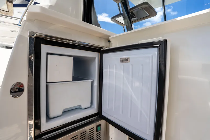 Soiral Yacht Photos Pics Open refrigerator on 2023 Prestige 520 yacht, showcasing interior storage space.