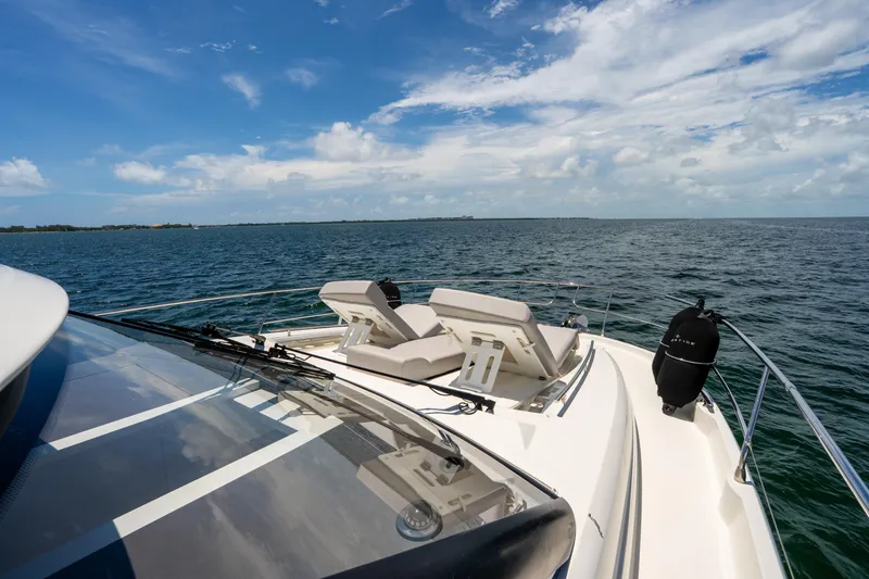 Soiral Yacht Photos Pics Luxury 2023 Prestige 520 yacht cruising on open sea under clear blue sky.