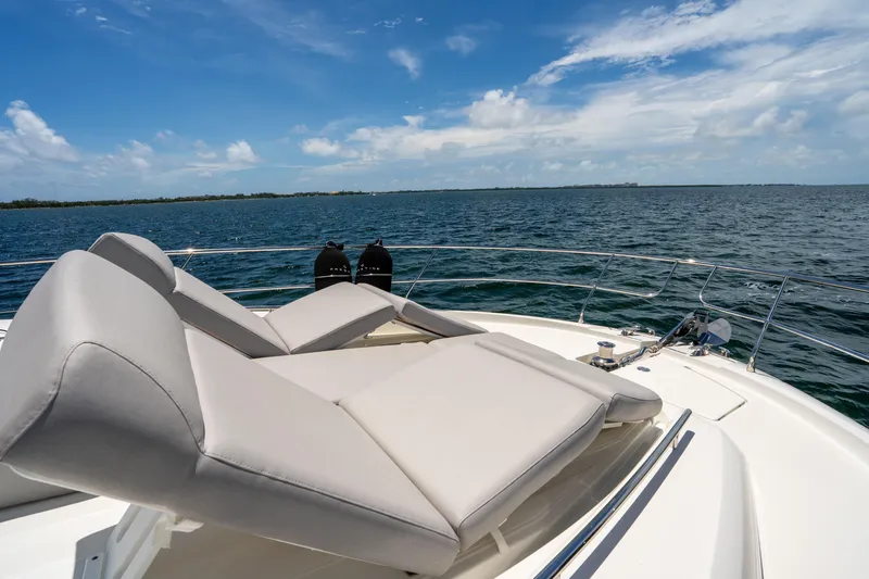 Soiral Yacht Photos Pics Luxurious 2023 Prestige 520 yacht with sun loungers on open sea.