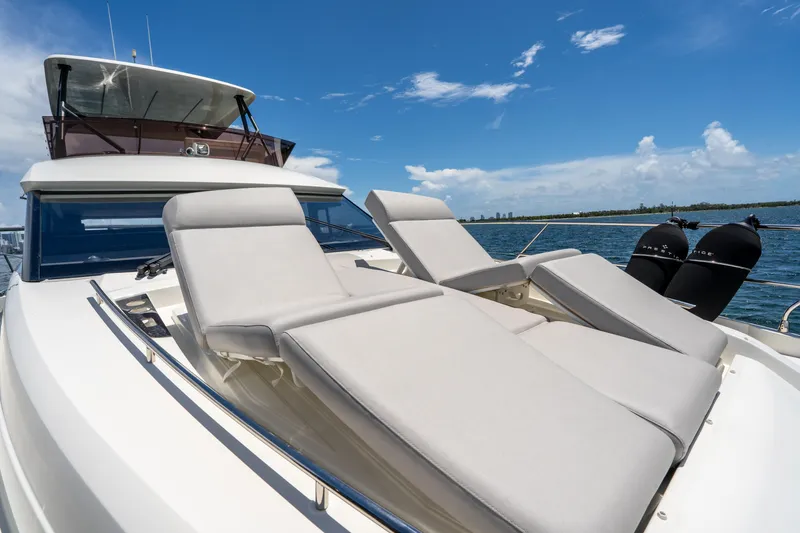 Soiral Yacht Photos Pics Luxury 2023 Prestige 520 yacht with sun loungers on deck, under clear blue sky.