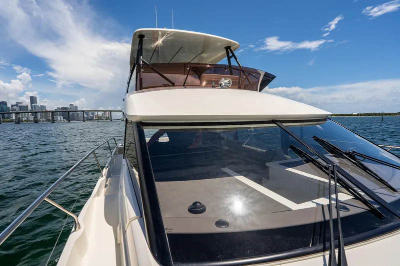 Soiral Yacht Photos Pics 2023 Prestige 520 yacht cruising on a sunny day with city skyline in background.