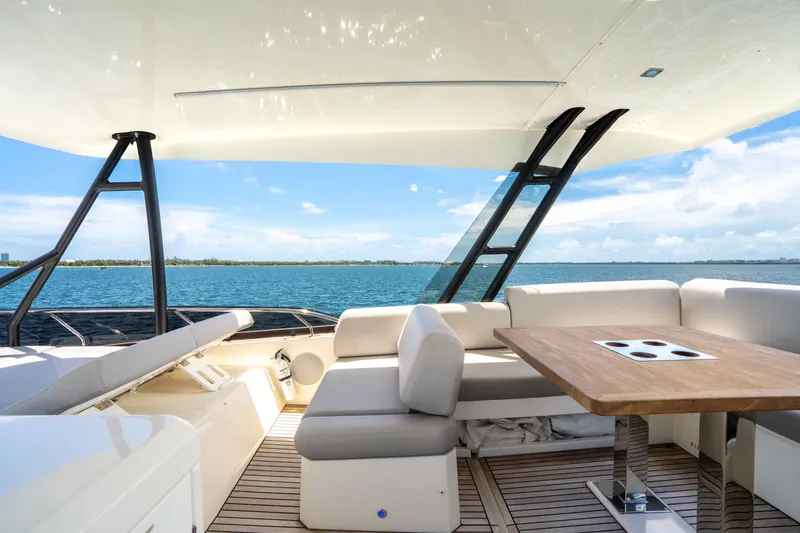 Soiral Yacht Photos Pics Luxurious 2023 Prestige 520 yacht interior with ocean view, featuring elegant seating and table.