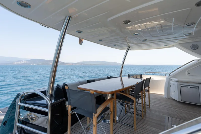 Mello Yacht Photos Pics Outdoor dining area on a 2008 Sunseeker 86 Yacht, overlooking the ocean.