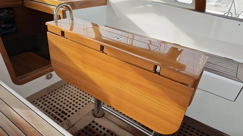 Hallberg Rassy 57 2020 Yacht Photos Pics Elegant wooden table on 2020 Hallberg-Rassy 57 yacht, showcasing sleek design and craftsmanship.