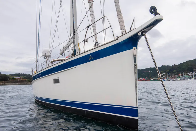 Hallberg Rassy 57 2020 Yacht Photos Pics 2020 Hallberg-Rassy 57 yacht anchored in calm waters, side view.