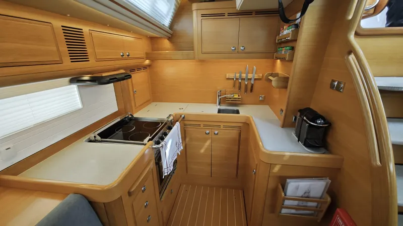 Hallberg Rassy 57 2020 Yacht Photos Pics Luxurious 2020 Hallberg-Rassy 57 yacht kitchen with modern appliances and wooden cabinetry.