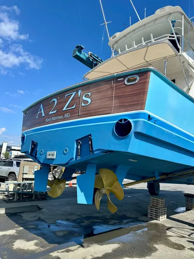 A2z's Yacht Photos Pics 1999 Viking 55 Convertible yacht with blue hull and dual propellers, docked on land.