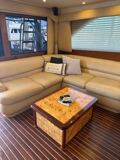 A2z's Yacht Photos Pics Luxurious interior of 1999 Viking 55 Convertible yacht with beige leather seating and wooden table.
