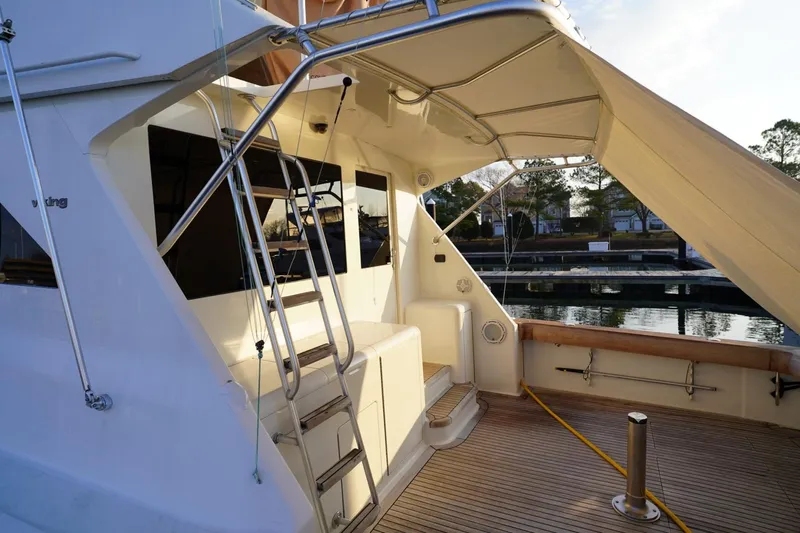 A2z's Yacht Photos Pics 1999 Viking 55 Convertible yacht with spacious deck and ladder, docked at marina.