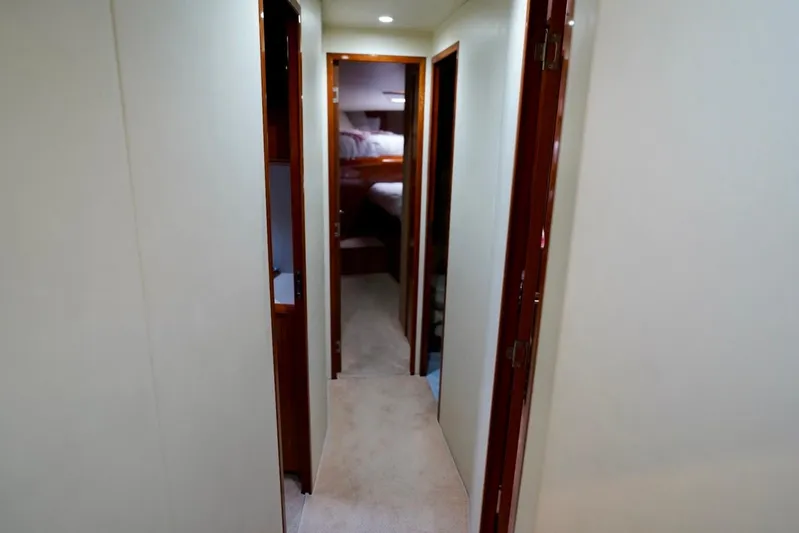A2z's Yacht Photos Pics Hallway inside 1999 Viking 55 Convertible yacht, featuring wooden doors and carpeted flooring.