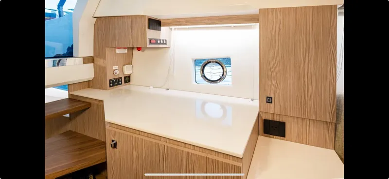  Yacht Photos Pics Modern interior of 2022 FIM 340 REGINA yacht with sleek wood finish and porthole window.
